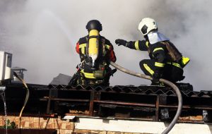 Rescuers extinguish a fire on a roof after the wreckage of a drone fell in the Solomianskyi district of Kyiv