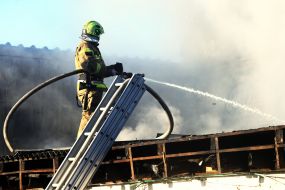 A rescuer extinguishes a fire on a roof after a drone wreckage fell in the Solomianskyi district of Kyiv