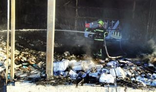 A rescuer puts out a fire after a drone wreckage falls in the Solomianskyi district of Kyiv