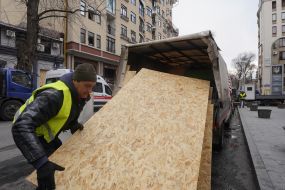 A municipal utility worker unloads chipboard slabs