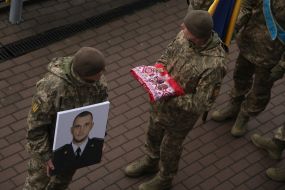 Servicemen hold a photo of Senior Lieutenant Pavlo Vedybida and his awards