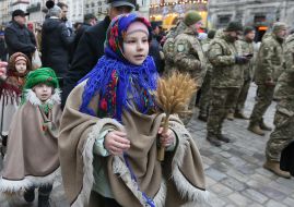 Дети в национальных украинских костюмах с маленькими дидухами из колосков в руках