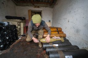 A serviceman of the 57th mortar brigade inspects shells in the Kharkiv region