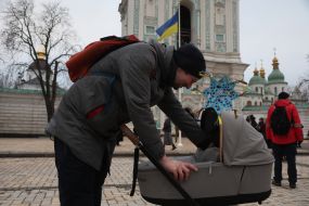 Man with a baby stroller with a Christmas star attached to it
