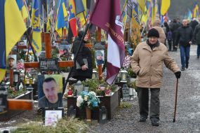 Relatives and friends near the graves of fallen defenders at the Lychakiv Cemetery