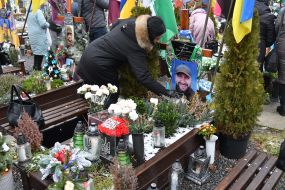 Relatives and friends near the graves of fallen defenders at the Lychakiv Cemetery