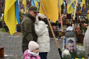Relatives and friends near the graves of fallen defenders at the Lychakiv Cemetery