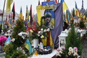 Relatives and friends near the graves of fallen defenders at the Lychakiv Cemetery