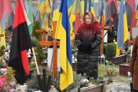 Relatives and friends near the graves of fallen defenders at the Lychakiv Cemetery