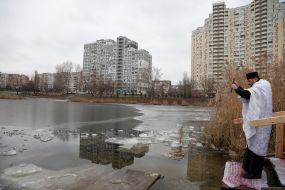 A priest blesses water in Lake Jordan in Kyiv