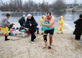 A man with a prosthetic leg emerges from the lake after Epiphany swimming in the lake at the Hydropark