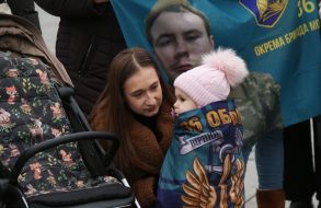 Жінка та дівчинка з військовим прапором на плечах на Майдані Незалежності в Києві