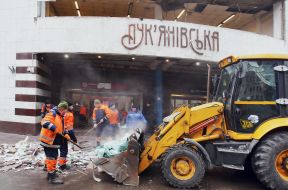 Сотрудники коммунального хозяйства ликвидируют последствия удара баллистикой возле станции метро "Лукьяновская" в центральном районе Киева