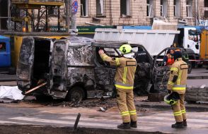Сотрудники ГСЧС ликвидируют последствия удара баллистикой возле станции метро "Лукьяновская" в центральном районе Киева
