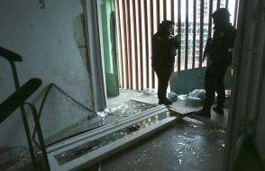 Эксперты-криминалисты фиксируют последствия удара баллистикой у станции метро "Лукьяновская" в центральном районе Киева