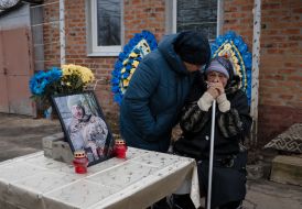 Женщины в скорби возле фотографии погибшего военнослужащего Александра Росторгуева