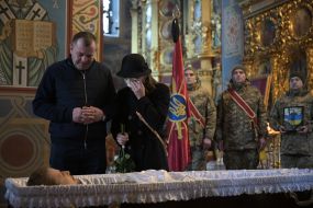 Parents Marcin Antosiak and Anzhelika Kuza say goodbye to their son at St. Michael's Cathedral in Kyiv