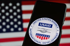 Емблема Агентства США з міжнародного розвитку (USAID) на екрані мобільного телефону