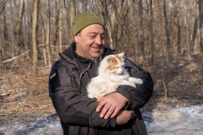 A serviceman of the 3rd Separate Iron Tank Brigade holds a cat in his arms in the Kharkiv region
