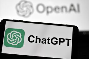 ChatGPT logo on a smartphone screen against the background of the logo of the developer company OpenAI