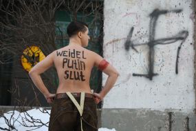 Topless FEMEN activist near the German Embassy in Kyiv