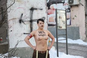 Topless FEMEN activist near the German Embassy in Kyiv