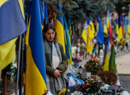 A woman prays at the graves of the fallen Heroes on the Hill of Glory in Uzhhorod