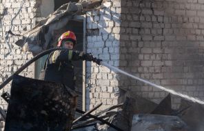 Rescuers extinguish a fire after a rocket attack on Kharkiv