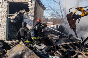 Rescuers extinguish a fire after a rocket attack on Kharkiv