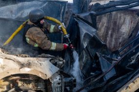 Rescuers extinguish a fire after a rocket attack on Kharkiv