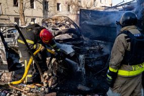 Rescuers extinguish a fire after a rocket attack on Kharkiv