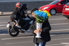 Young man with a bouquet in the colors of the Ukrainian flag