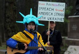 An activist dressed as the Statue of Liberty wrapped in the flag of Ukraine