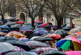Believers walk under umbrellas through the streets of Uzhhorod