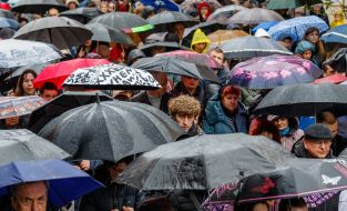 Believers walk under umbrellas through the streets of Uzhhorod