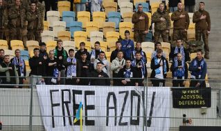 Fans in the stands with a "Free Azov" poster