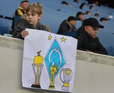 Boy cheerleader with a poster on the stands