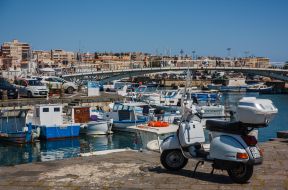 Fishing boats and a moped in the port of Syracuse