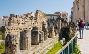 Туристи оглядають руїни храму Аполлона в місті Сіракуза