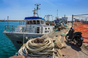 Рибальські катери та мопед у порту міста Катанія