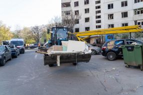 Трактор разгребает завалы возле дома после удара баллистическими ракетами с кассетной начинкой по Харькову