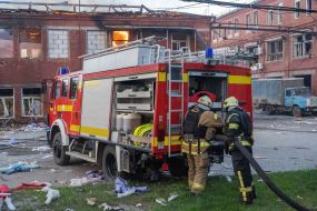 Rescuers prepare equipment to extinguish a fire in a house after a ballistic missile attack with cluster munitions on Kharkiv