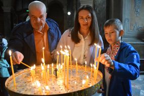 Believers light candles in church