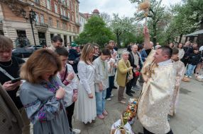 Священик окроплює святою водою вірян