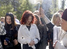 Священник окропляет святой водой верующих