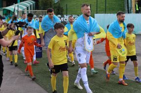 Football players enter the field accompanied by children