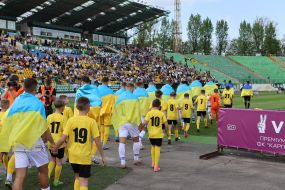 Football players enter the field accompanied by children