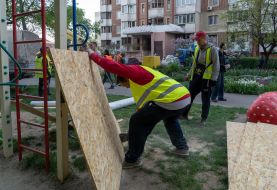 Utility workers prepare plywood to board up windows after massive Russian attack on Kharkiv
