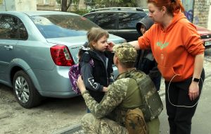 A soldier calms a girl after a massive Russian attack on Kyiv