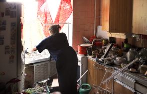 Woman cleaning glass near broken window in apartment after a massive Russian attack on Kyiv
